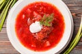 Borscht with sour cream and herbs on a wooden background, top view Royalty Free Stock Photo