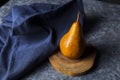 Bosc pear on wood and accompanied by a blue cloth napkin Royalty Free Stock Photo