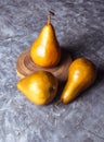 Bosc pear in yellow tone, which is distinguished by its elongated shape. These pears are on a gray wooden board and accompanied by Royalty Free Stock Photo