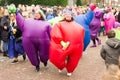 Cheerful ladies dressed in colored inflatable suits during the carnival parade in Boskoop