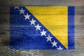 Bosnia Herzegovina flag on rustic old wood surface background Royalty Free Stock Photo