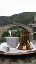 Bosnian coffee with delight and traditional copper serving set  in front of Old bridge in Mostar, Bosnia and Herzegovina Royalty Free Stock Photo