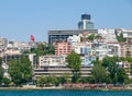 Bosporus coast residential buildings and large Turkish flag as seen from a ship sailing Bosporus waters