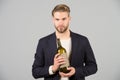 Boss with bottle of wine in hands. Bearded man hold alcoholic drink. Sommelier or degustator with wine. Alcohol addiction and bad Royalty Free Stock Photo