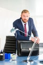 Boss at desk leaning over briefcase