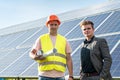 boss and the employee are standing near the solar panels