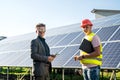 boss and the employee are standing near the solar panels