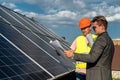 boss and the employee are standing near the solar panels