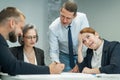 The boss gives instructions to three employees in the office conference room. Brainstorming engineers and architects.