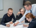 The boss gives instructions to three employees in the office conference room. Brainstorming engineers and architects.