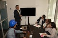Boss giving a presentation to his team in the boardroom based on audiovisual tools to express ideas and concepts