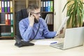 The boss in the office at his desk talking on the phone, holding a financial report in his hands. Manager`s phone call about Royalty Free Stock Photo