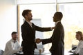 Boss praises handshaking African member during briefing in office boardroom