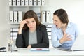 Boss scolding an emlployee looking at camera Royalty Free Stock Photo