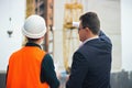 Boss shows a construction project to engineer. Business modern background