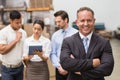 Boss standing with arms crossed in front of his employees Royalty Free Stock Photo