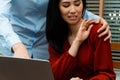 Boss touching shoulder of a young female employee in office at workplace. She is uncomfortable and afraid of sexual inappropriate Royalty Free Stock Photo