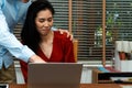 Boss touching shoulder of a young female employee in office at workplace. She is uncomfortable and afraid of sexual inappropriate Royalty Free Stock Photo