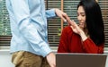 Boss touching shoulder of a young female employee in office at workplace. She is uncomfortable and afraid of sexual inappropriate Royalty Free Stock Photo