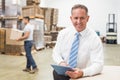 Boss using digital tablet in warehouse