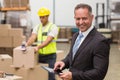 Boss using digital tablet in warehouse