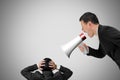 Boss using megaphone yelling at his employee with concrete wall Royalty Free Stock Photo