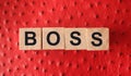 Boss word letters on a wooden cubes put on red leather. Business leader concept Royalty Free Stock Photo