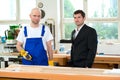 Boss and worker in a carpenter's workshop Royalty Free Stock Photo