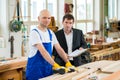Boss and worker in carpenter's workshop Royalty Free Stock Photo