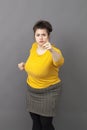 Bossy 20s fat woman showing her index and fist to denounce