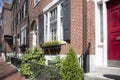 Boston, MA - April 8 2021: Front of brownstone apartment brick building with windows, shutters, stoops and planters in Boston