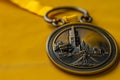 Victory and Valor Close-Up of a Solemn Boston Marathon Medal Against a Golden Backdrop