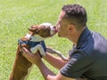 Boston terrier puppy kissing a young Hispanic man