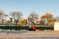 Couple sit on esplanade beside Storrow lagoon in late afternoon sun on an autumn day with Charles River and city in view Royalty Free Stock Photo