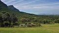 The botanical garden has a green lawn, many trees and shrubs.