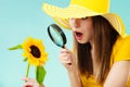 Botanist woman with sunflower and magnifying glass