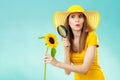 Botanist woman with sunflower and magnifying glass