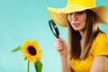 Botanist woman with sunflower and magnifying glass