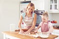 They are both avid bakers. Cute little girl baking in the kitchen with her mom.