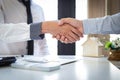 Both businessmen shake hand to congratulate them on their successful signing of a contract with a home insurance agent