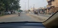 Both sides of road is clearly visible where one woman is riding on a two wheeler in India