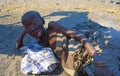 Botswana: A old bushmen woman lying on the sand in the shadow of the central Kalahari