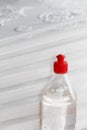 Bottle with acrylic, versatile glue designed for repair work, stands against the background of pressed foam plates for ceiling