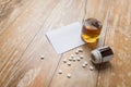 Bottle of alcohol and pills on table