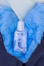 Bottle with antibacterial gel in the hands in protective gloves