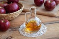 A bottle of apple cider vinegar with fresh apples in a basket Royalty Free Stock Photo