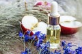 Bottle of apple essential oil and fresh apples on a wooden table. Essential oil is used to fill lamps, perfumes and in cosmetics