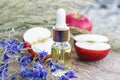 Bottle of apple essential oil and fresh apples on a wooden table. Essential oil is used to fill lamps, perfumes and in cosmetics