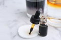 Bottle of aqueous iodine and glasses with liquids of different colors on white marble table, selective focus. Space for text Royalty Free Stock Photo