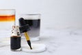 Bottle of aqueous iodine and glasses with liquids of different colors on white marble table, selective focus. Space for text Royalty Free Stock Photo